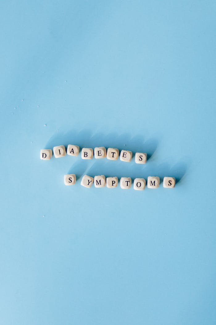Cubes spelling 'Diabetes Symptoms' on a light blue background for health awareness.